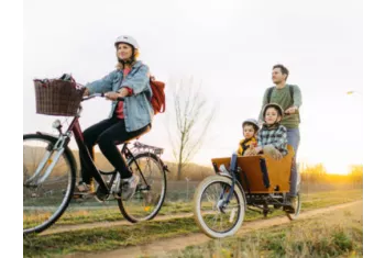 Personne roulant sur un vélo cargo avec ses 2 enfants