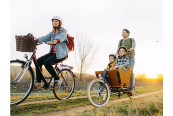 Personne roulant sur un vélo cargo avec ses 2 enfants