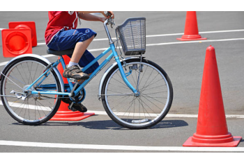 Photo d'un enfant réalisant un parcours à vélo avec des cônes