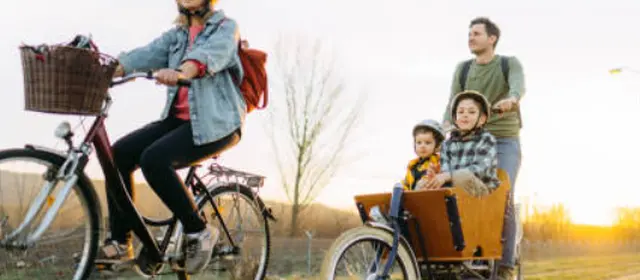 Personne roulant sur un vélo cargo avec ses 2 enfants