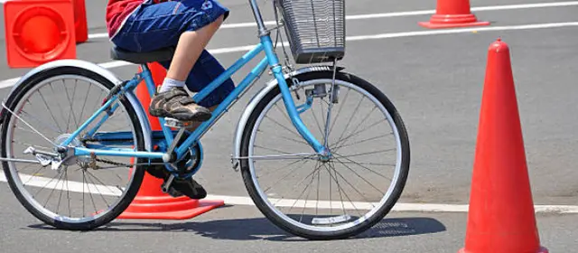 Photo d'un enfant réalisant un parcours à vélo avec des cônes